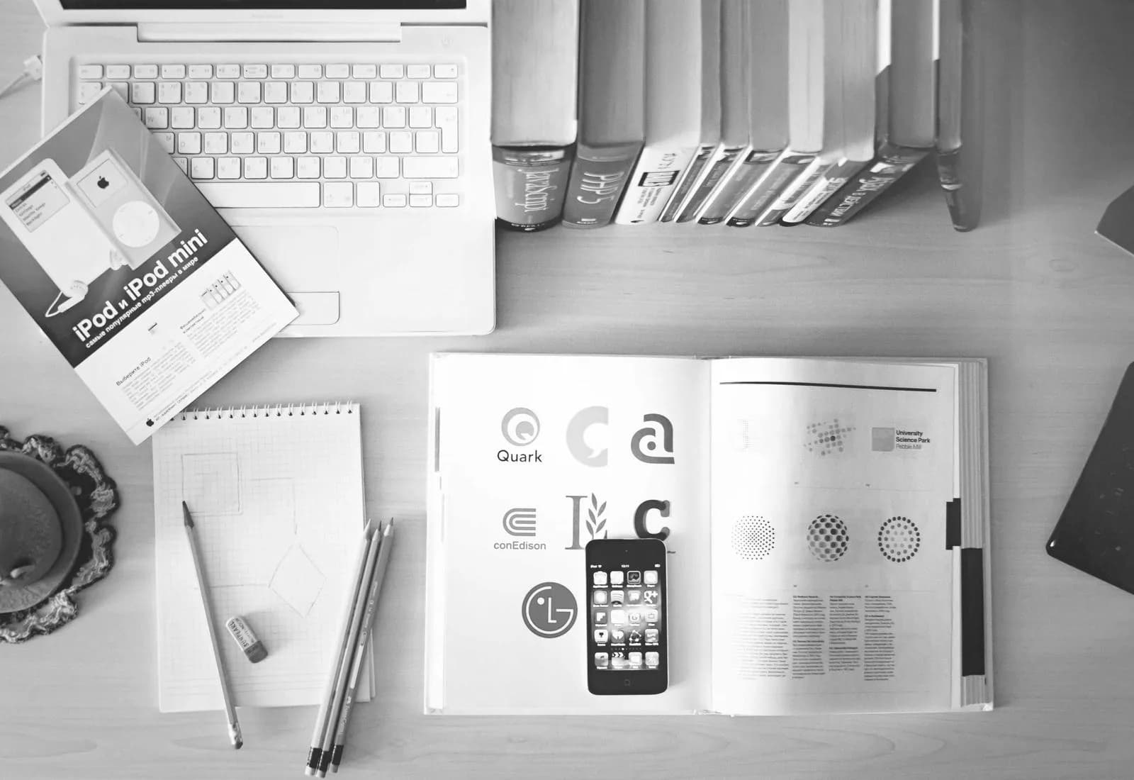 Magazine ouvert, clavier et feuilles disposés sur un plan de travail.